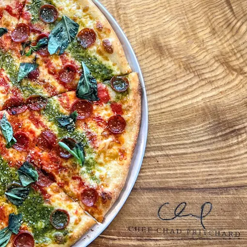 A freshly-baked New York style pizza with melted cheese and basil