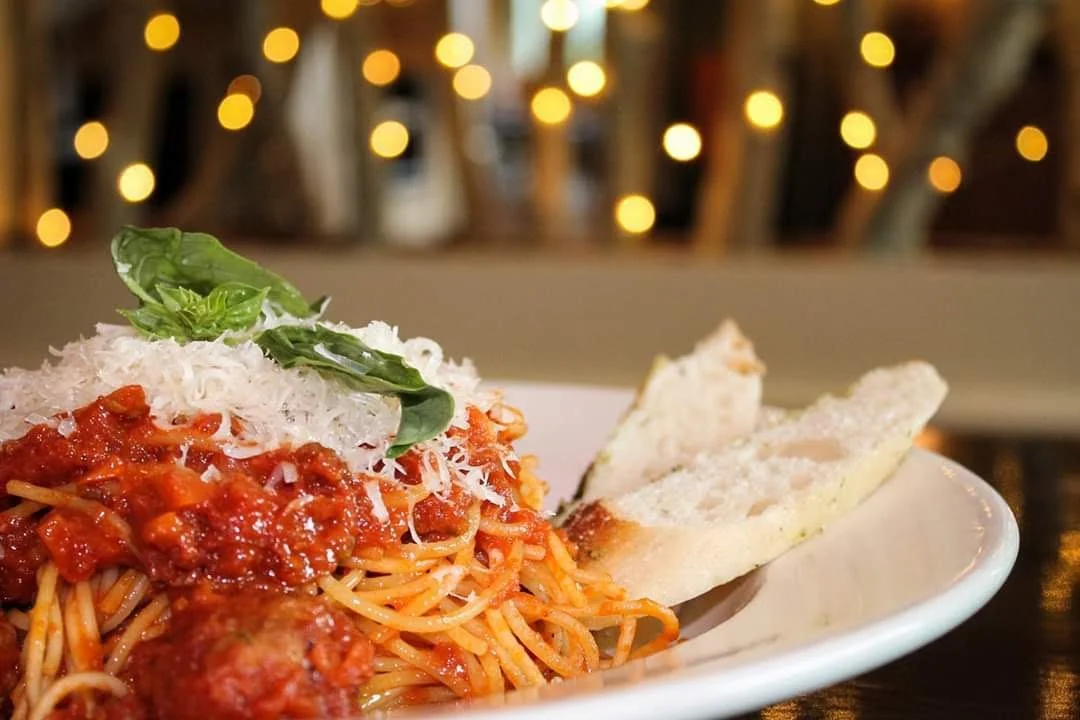 A second plate of pasta twirled on a fork